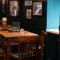 An interior restaurant seating area at the Royal George in Euston; with an upholstered booth seat, and framed artwork on the walls.