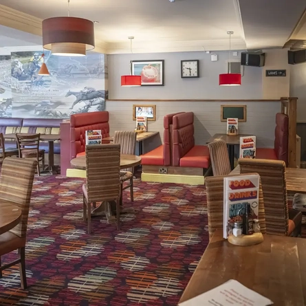 Interior dining area of a pub with a claw machine.