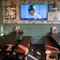 An interior restaurant seating area at the Green Posts, with a TV on the wall, and upholstered bench seating.