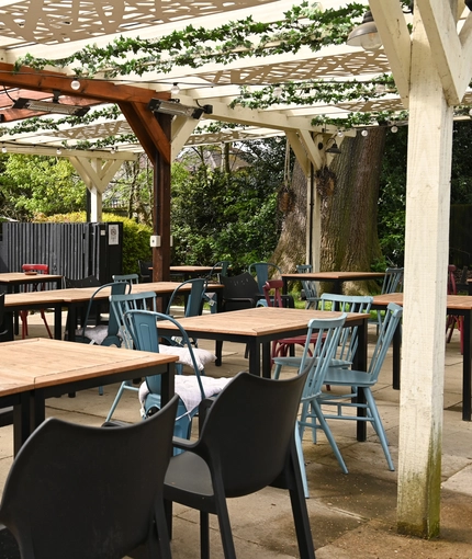 Exterior beer garden of a pub with a gazebo, a seating area and a TV.