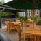 The exterior patio beer garden seating area with wooden tables, chairs and advertising signage at The Church View Inn.