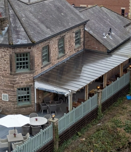 An aerial view of the exterior facade and beer garden seating area of The Malthouse Farm, and the canal that runs alongside the pub.