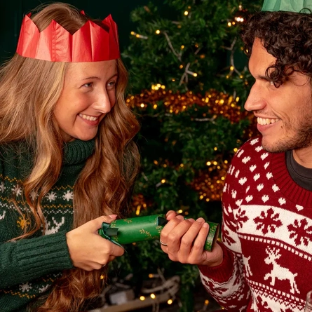 Two people pulling a Christmas cracker