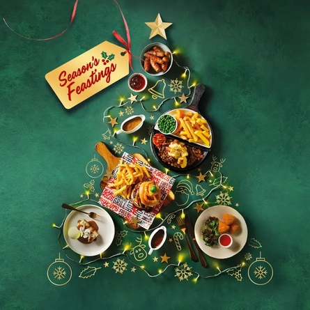 A variety of dishes arranged in the shape of a Christmas tree, with a gift tag that says 'seasons feastings' attached to the top of the tree.