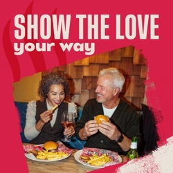 A banner featuring the words "Show the love your way" above an image of a couple enjoying a meal at a restaurant table, promoting Valentine's Day at Flaming Grill.