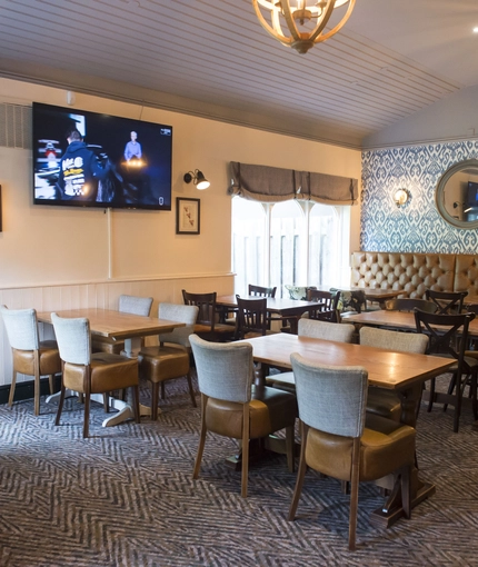 Interior dining area of a pub with a TV.