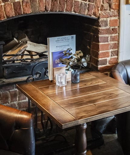 The interior restaurant seating area with feature fireplace and two chalkboards at The Bull.