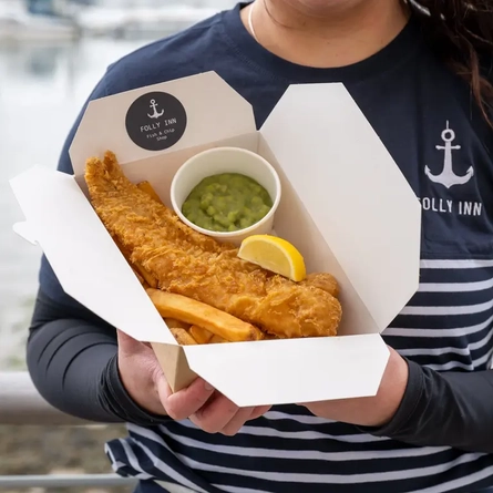 Close up of someone holding a fish and chips meal
