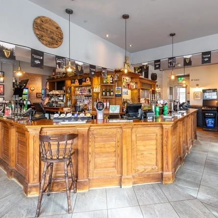 The interior bar and seating area with dartboard and electronic pub game at The Black Bull.