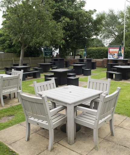 Exterior beer garden of a pub with a seating area.