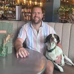 Charlie Higgens, sitting at a table in The Prince Of Wales, with a dog next to him.