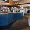 The bar area of The White Hart, with some stools around it.