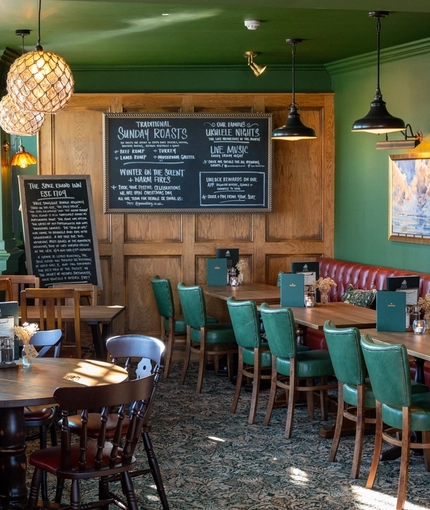 The interior restaurant seating area with tables, chairs, wooden panelling feature wall with advertising chalkboard at The Spice Island.