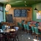 The interior restaurant seating area with tables, chairs, wooden panelling feature wall with advertising chalkboard at The Spice Island.