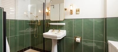 A hotel room ensuite with mirror, ornate sink, shower and WC in one of the bedrooms at The Dog and Partridge.
