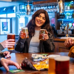 A group of people enjoying a beer at a table.