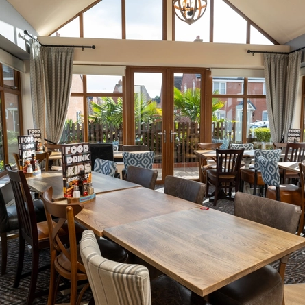 An interior restaurant seating area at The Hansom Cab, with floor to ceiling windows and curtains.