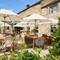 The exterior beer garden seating area of the Smiths Arms pub in Beckwithshaw, with shade umbrellas, plants, and wooden furniture.