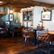 The restaurant area of The White Hart, with a fireplace amongst the tables.