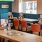 An interior restaurant seating area at The Tamar in Crownhill, with upholstered bench and booth seating, and a TV on the wall.