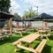 The exterior beer garden seating area with wooden tables and umbrellas, at The Belfry in Beighton.