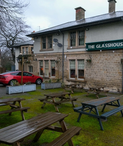 Exterior facade and beer garden of a pub with a seating area.