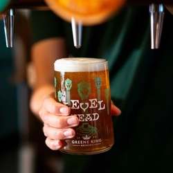 A close up image of a pint of Level Head being poured behind the interior bar at a Community Pubs With Food venue.