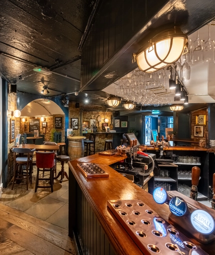 The bar in the Prince Of Wales, and some tables near to it.
