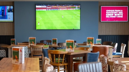 The interior restaurant and seating area with TV at The Woodlands.