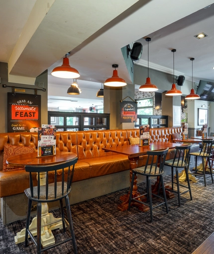 Interior dining area of a pub with a TV.