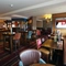 Interior dining area of a pub with a bar and a TV.