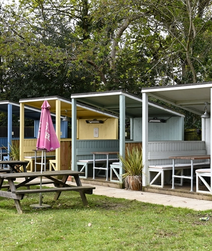 Exterior beer garden of a pub with a seating area and gazebos.