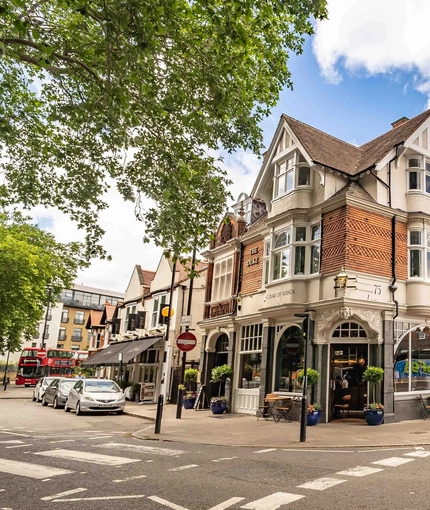 The exterior facade with venue signage, potted trees and outdoor seating with tables & chairs at The Duke Of Sussex.
