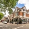 The exterior facade with venue signage, potted trees and outdoor seating with tables & chairs at The Duke Of Sussex.