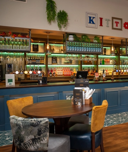 The bar and interior restaurant seating area at The Kittoch, with a TV on the wall.