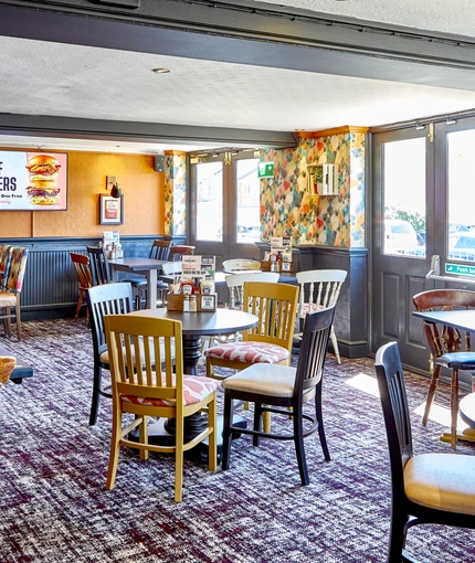 The interior restaurant seating area with TV, at The Good Intent in Hornchurch.