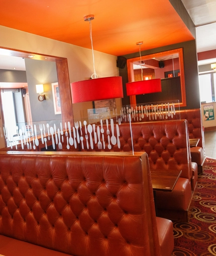 Interior dining area of a pub with a few TVs.