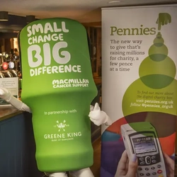 A life-size Macmillan charity pot in front of a bar.