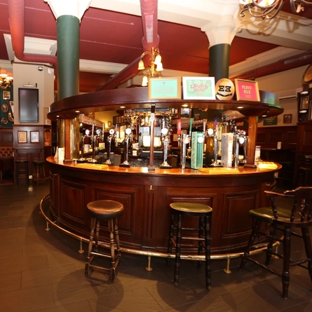 The interior bar with stool seating and restaurant seating area with TV at The Rhoderick Dhu.