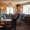 The interior restaurant seating area at the Rudds Arms in Marton-In-Cleveland; with an upholstered booth seat in the corner by the windows, and framed artwork on the walls.