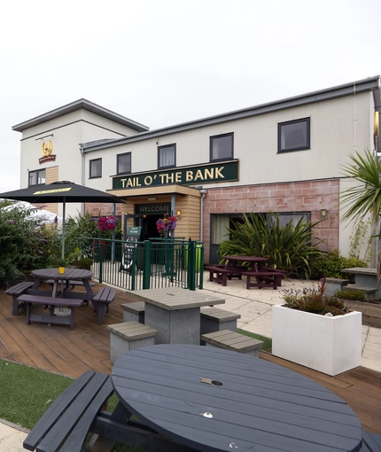 Exterior beer garden of a pub with a seating area and a play area.