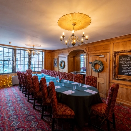 A long table with lots of seats in a function room.
