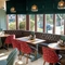 An interior restaurant seating area at the Golden Hind, with a long, upholstered booth seat running along the large bay window.