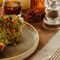 An advertising image of a Schnitzel dish with a glass of white wine within the interior restaurant seating area at The Foundry Bell.