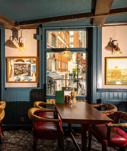 The interior restaurant and seating area next to two large windows at the Three Jolly Butchers.