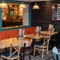 The interior restaurant seating area at The Lodge in Alvaston, with an upholstered booth seat, and a TV on the wall above it.