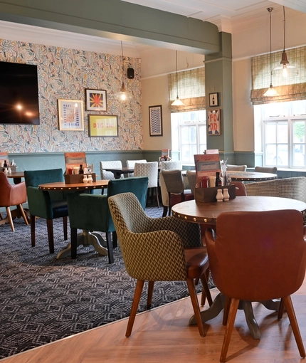 The interior restaurant seating area with TV at The Greengage.