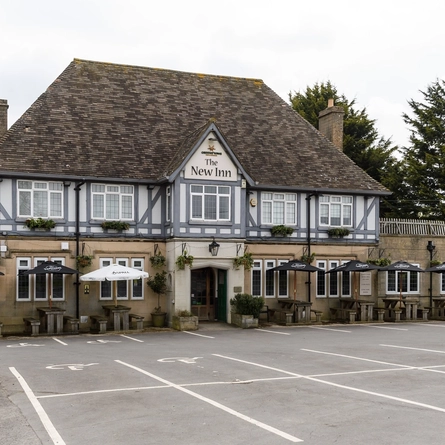 Exterior facade and car park of a pub.