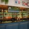 The bar inside The Kittoch in East Kilbride, with potted plants and bottles of wine on shelves above the counter, and bottles of alcoholic spirits on illuminated shelves behind the bar.