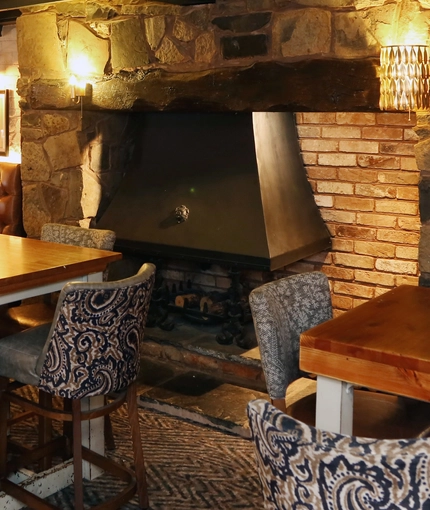 Interior dining area of a pub with a fireplace.